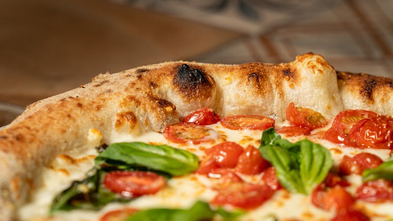 Wood-fired pizza emerging from the oven at Pizzana