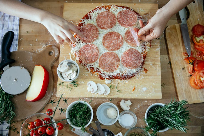 Fresh pizza ingredients laid out on a wooden board